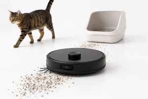 Robot aspirador recogiendo arena de gato junto al arenero